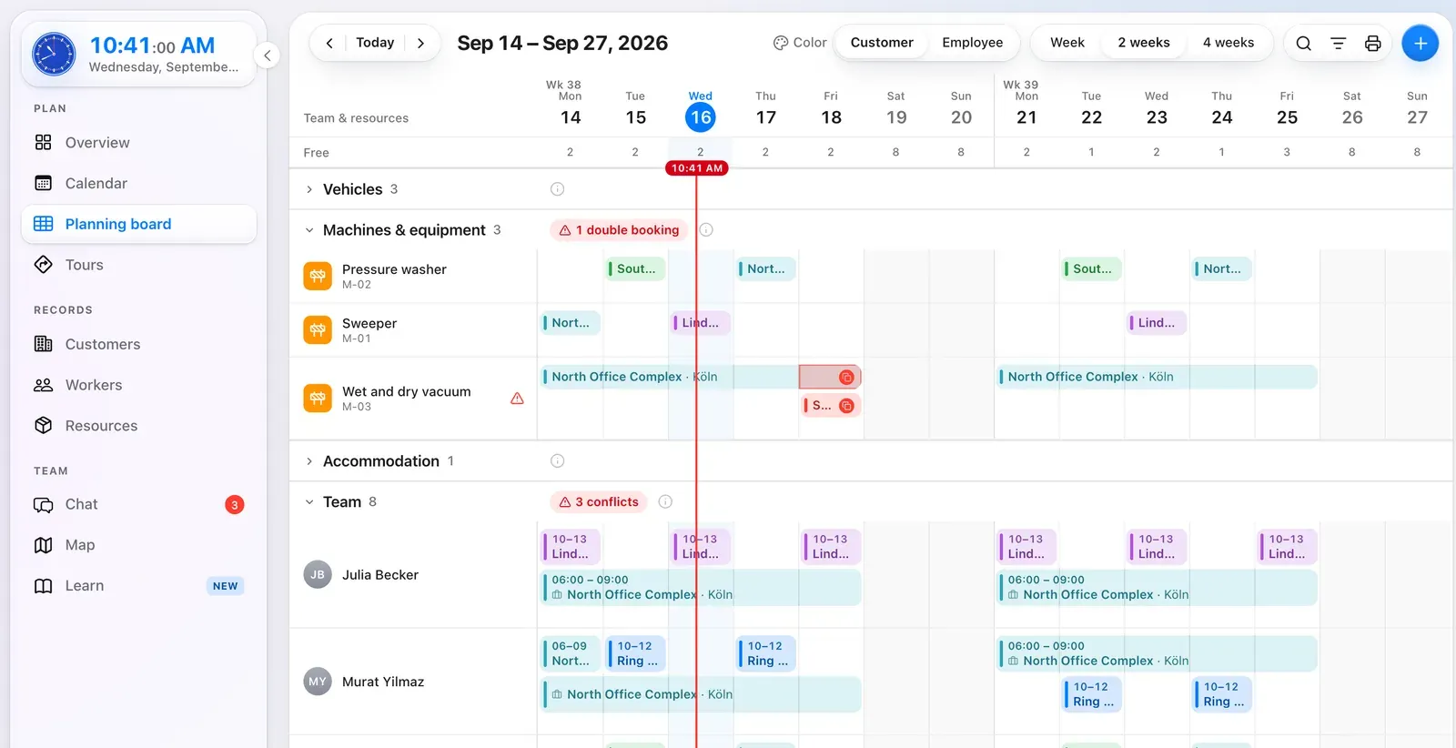 Planning board in Crew Active: machines and team members as rows, two weeks as columns, with jobs and one double booking; vehicles and accommodation folded away (sample data)